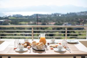 a table with breakfast food on a balcony with a view at Elounda Dream House in Elounda