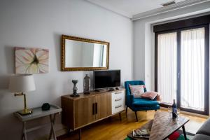 een woonkamer met een tv en een blauwe stoel bij Figueroa Design in Madrid