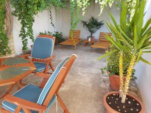 un patio con sillas, mesas y macetas en Apartment Tisno Residence en Tisno