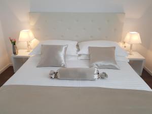 a white bed with two pillows and a purse on it at Apartment Tisno Residence in Tisno