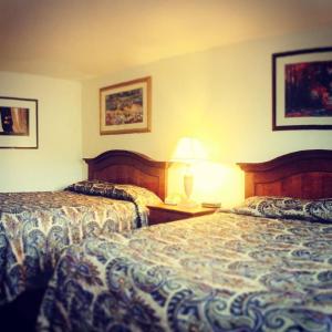 a hotel room with two beds and a lamp at Budget Inn Express Helena in Helena