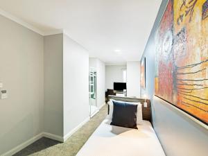 - une chambre avec un lit et une grande peinture murale dans l'établissement 28 Hotel, à Sydney