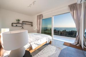 a bedroom with a bed and a large window at Villa Olea, luxury retreat with nature blend in Novalja