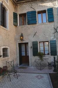 un bâtiment avec des fenêtres à volets bleus et un vélo devant lui dans l'établissement Casetta Al Ponte, à Cison di Valmarino