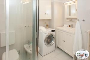 een witte badkamer met een wasmachine en een wasmachine bij LA CASA DI GLADYS in Lecco