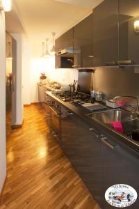 een keuken met zwarte kasten en een houten vloer bij LA CASA DI GLADYS in Lecco