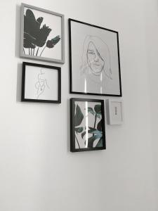 a group of framed pictures on a wall at Atelier 3 in Loulé