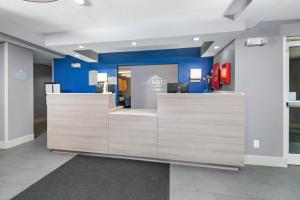 vestíbulo de una oficina dental con mesas de recepción de madera en Microtel Inn & Suites by Wyndham Bethel/Danbury en Bethel