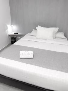 a black and white photo of a bed with a towel on it at KLEINN HOTEL BOGOTÁ in Bogotá