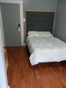 Un pat sau paturi într-o cameră la Winsor Hotel