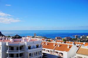 uitzicht op de daken van gebouwen en de oceaan bij 2-bedroom 4-star apartment in Los Christianos in Los Cristianos
