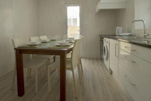 uma cozinha com uma mesa com cadeiras e um lavatório em Azores Patio House em Ponta Delgada