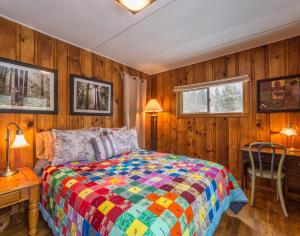 - une chambre avec un lit coloré et des murs en bois dans l'établissement Zuni's Cabin, à Leadville