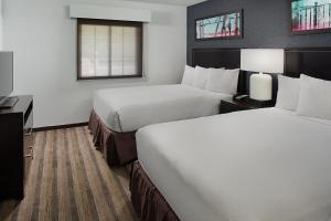 エル・セグンドにあるHyatt House LAX Manhattan Beachのベッド2台とテレビが備わるホテルルームです。