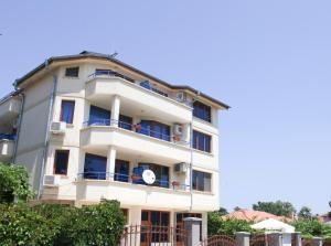 een wit gebouw met blauwe balkons bij Dream House in Ahtopol