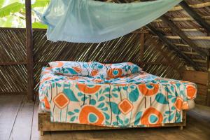 a bed in a thatched room with a canopy at The Humpback Turtle in El Valle