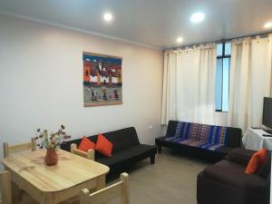 瓦拉斯的住宿－Huaraz Apartamentos，客厅配有沙发和桌子