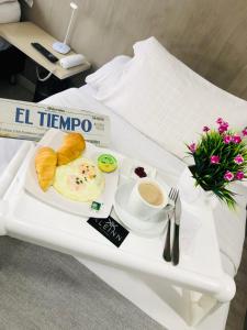 bandeja de desayuno con huevos, pan y café en una mesa en KLEINN HOTEL BOGOTÁ, en Bogotá