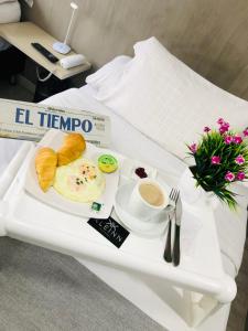 a breakfast tray with eggs and bread and coffee on a table at KLEINN HOTEL BOGOTÁ in Bogotá