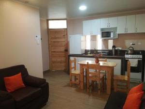 a kitchen and dining room with a table and a couch at Huaraz Apartamentos in Huaraz