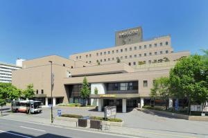 a building with a bus parked in front of it at Hotel Sapporo Sun Plaza in Sapporo