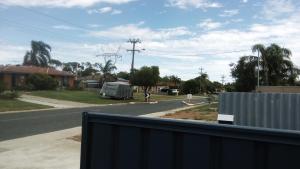 a view of a street from a house with a fence at Airport budget room in Perth