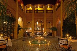 
a large room filled with tables and chairs at Riad Le Perroquet Bleu Suites & Spa in Marrakech
