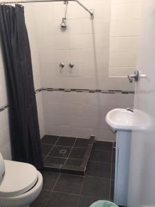 a bathroom with a shower and a toilet and a sink at Port Adelaide Backpackers in Adelaide