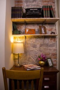 a desk with a lamp and books on a brick wall at Luma B&B Boutique in Puebla