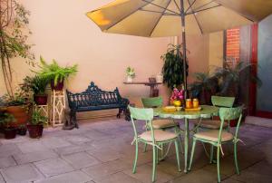 einen Tisch und Stühle mit einem Regenschirm und einer Bank in der Unterkunft Luma B&B Boutique in Puebla
