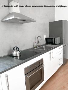 een witte keuken met een wastafel en een magnetron bij Atelier 3 in Loulé