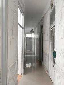 un pasillo vacío con paredes blancas y una puerta en Atelier 3, en Loulé