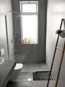 a bathroom with a toilet and a sink and a window at Atelier 3 in Loulé