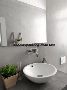 een badkamer met een witte wastafel en een spiegel bij Atelier 3 in Loulé