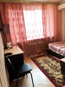 1 dormitorio con escritorio, 1 cama y ventana en Svetlana Hotel, en Artem
