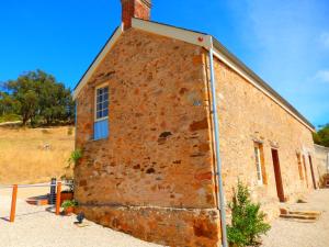 a brick building with a clock on the front of it at Morialta Barns in Norton Summit