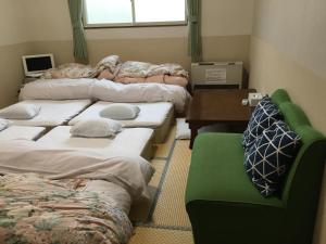 a room with several beds and a desk and a table at Lodge Christmas Rose Zao in Zao Onsen
