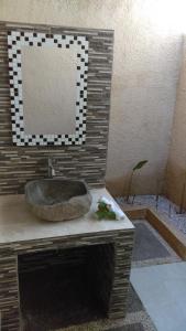 a bathroom with a stone sink on a counter at La Gautch Bungalow in Nusa Lembongan