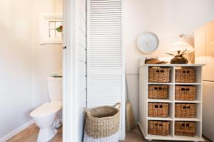 a bathroom with a toilet and wicker baskets at The Oar House in Metung +33 photos