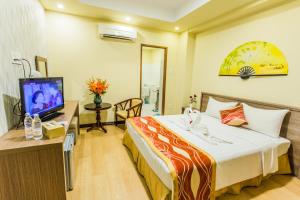 een hotelkamer met een bed en een televisie bij Golden Gate China Town Hotel in Yangon