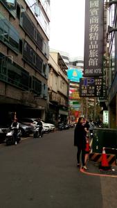 a woman walking down a street in a city at Persimmon Hotel in Hsinchu City