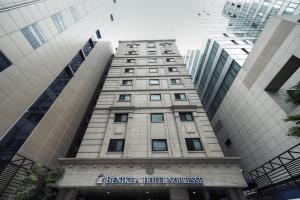 a tall building with a sign for a hotel at Hotel Noblesse, Yeoksam in Seoul