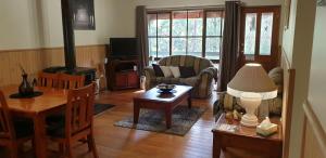a living room with a table and a fireplace at Day Dream Cottage in Halls Gap