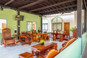 a living room with wooden tables and chairs at Reveal Angkor Hotel in Siem Reap