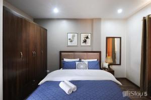 - une chambre dotée d'un grand lit avec des draps bleus et blancs dans l'établissement ISTAY Hotel Apartment 5, à Hanoï