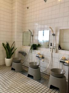 a bathroom with three sinks and two mirrors at Akakura Akarien in Myoko