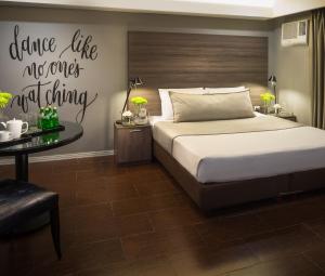1 dormitorio con 1 cama y 1 mesa en Astoria Greenbelt, en Manila