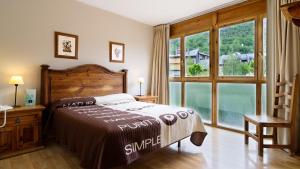 a bedroom with a bed and a large window at Hotel La Posada in Broto