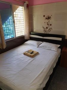 a large white bed with a tray on top of it at Rks Homestay in Hampi