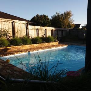 a swimming pool in a backyard with a fence at Kerikeri Central Apartment in Kerikeri